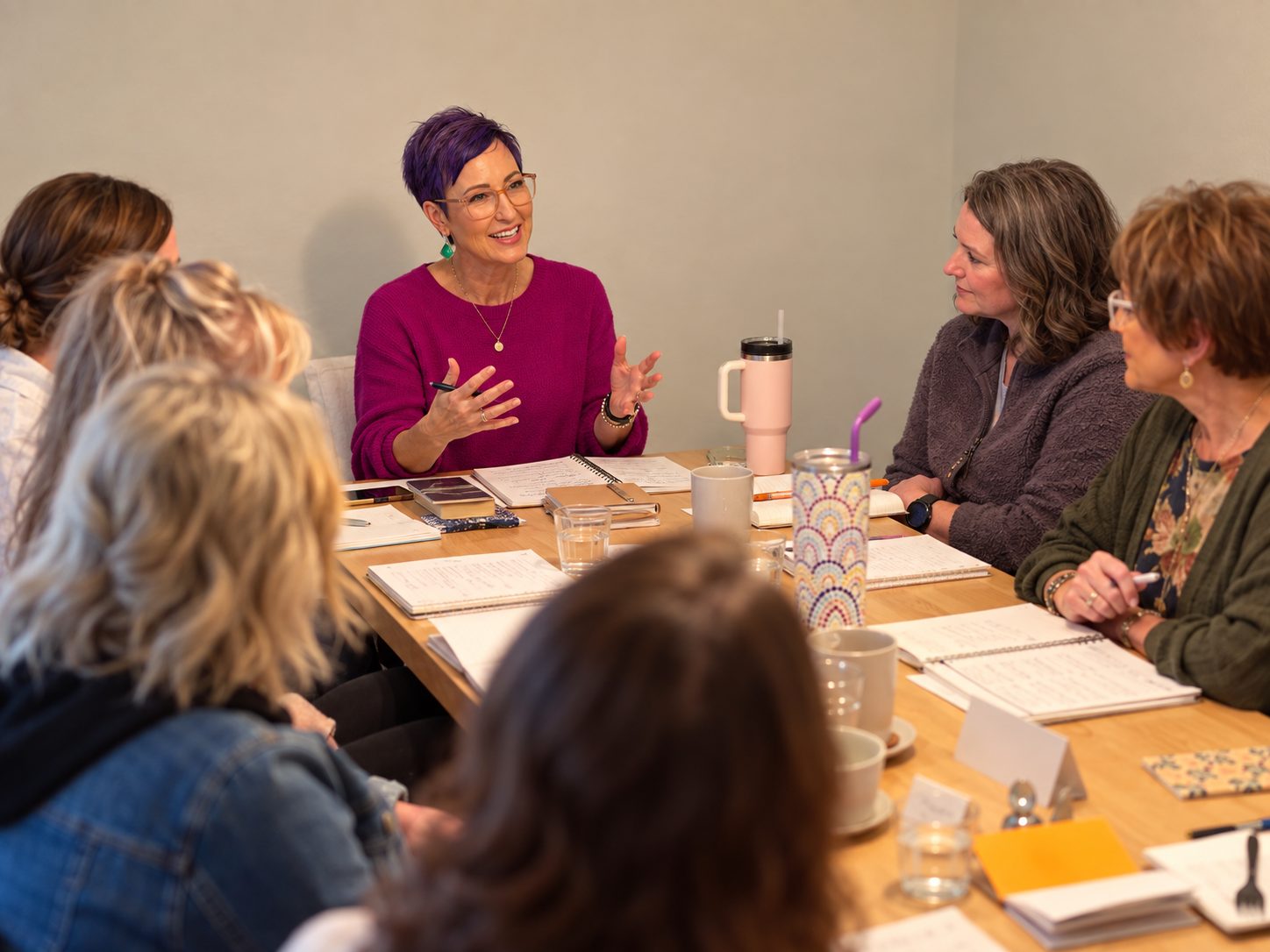 Kendri Burkett leading an Enneagram coaching workshop for a team around a table